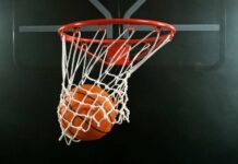 A basketball going through a hoop with a smoky background