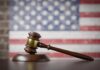 Supreme Court ERUPTS – Justices Exchange Angry Charges A wooden gavel resting on a sound block with an American flag background