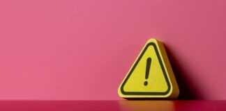 Yellow triangular warning sign on a pink background