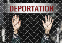 Hands reaching through a chain-link fence with the word 'DEPORTATION' above