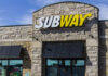 Exterior view of a Subway restaurant with a prominent sign
