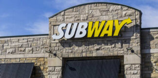 Exterior view of a Subway restaurant with a prominent sign