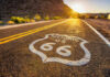 USPS STUNS With Route 66 Stamp Release Historic Route 66 sign painted on a road at sunset