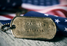 Dog tag and American flag honoring veterans.