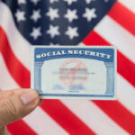 Social Security Doomed? Is THIS the Answer? Hand holding social security card, American flag background.