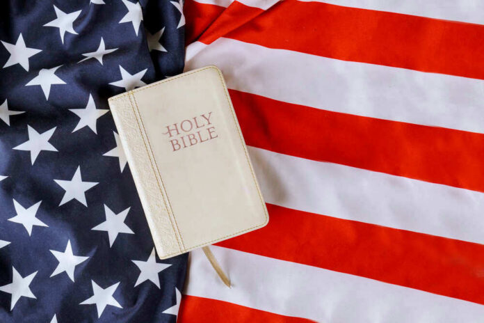 shutterstock_1739139314 Bible on an American flag background.