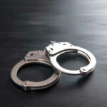 Parents Accused After 255-Pound Death Metal handcuffs on a dark textured surface.