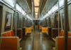 Empty subway train with orange seats.