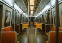 Empty subway train with orange seats.