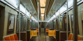 Empty subway train with orange seats.