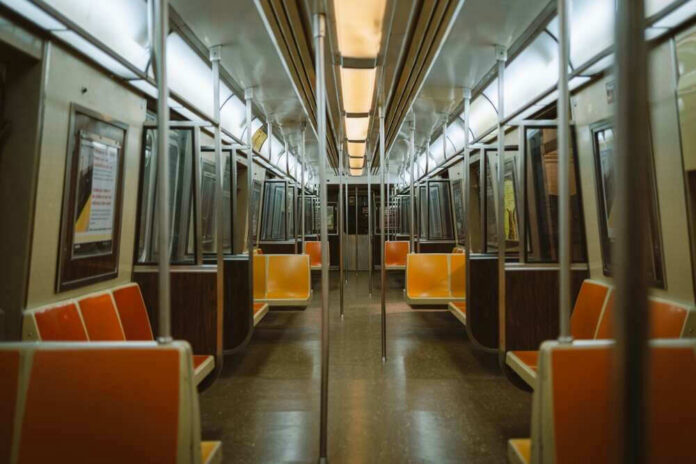 Empty subway train with orange seats.