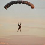 Tandem Jump Turns Fatal Silhouette of a helicopter with two individuals being lowered by ropes