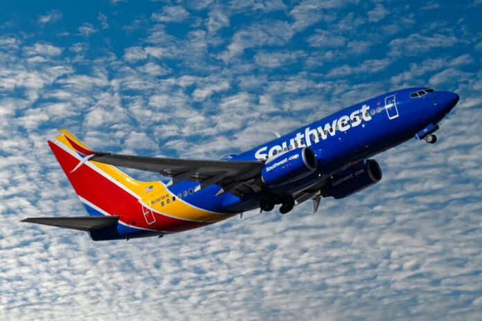 shutterstock_2415377835 Southwest airplane on the air with blu sky and white clouds.