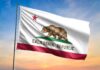 California state flag waving against a sunset sky