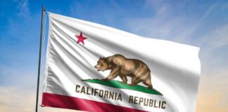 California state flag waving against a sunset sky