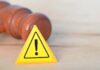 Judge Slams $1.8B ‘Slush Fund’ Yellow warning triangle with exclamation mark beside a wooden gavel