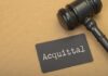 A gavel next to a card that reads 'Acquittal'