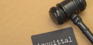 A gavel next to a card that reads 'Acquittal'