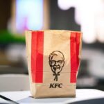 Chicken Wars Reloaded: KFC’s Bold Gambit KFC takeout bag on a table in a restaurant