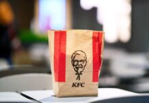 Chicken Wars Reloaded: KFC’s Bold Gambit KFC takeout bag on a table in a restaurant