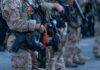 Law enforcement officers in tactical gear holding weapons