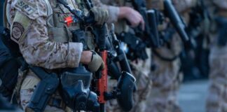 Law enforcement officers in tactical gear holding weapons