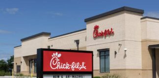 Exterior view of a Chick-fil-A restaurant with a promotional sign