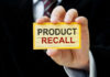 Vehicle Fire Risk Escalates To Massive Recall Hand holding a product recall card