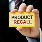 Vehicle Fire Risk Escalates To Massive Recall Hand holding a product recall card