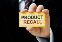 Hand holding a product recall card