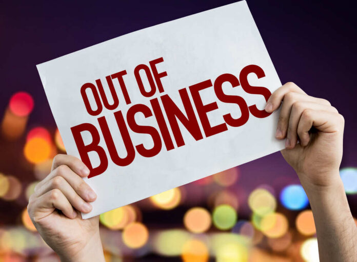 Out,Of,Business,Placard,With,Night,Lights,On,Background