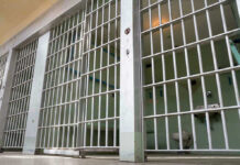 Detention Boom Soars — 43,138 Arrests! Empty prison cell with metal bars and toilet.