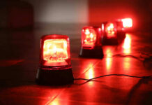 Nationwide Tick Spike?! Red emergency lights on dark floor, illuminating the area.