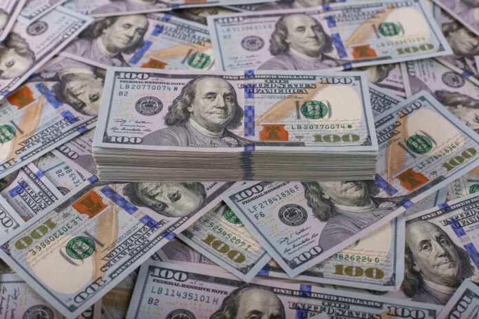 shutterstock_1257954658 Stack of one hundred dollar bills, Benjamin Franklins portrait.