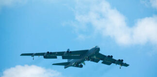 Large military aircraft flying with landing gear down