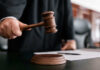 Tesla Trunk Horror: Pop Star Put On Trial Judge holding gavel in courtroom.