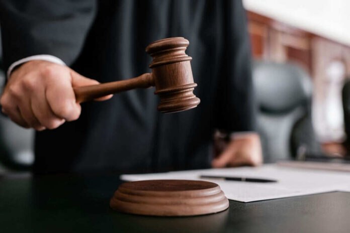 shutterstock_2121705137 Judge holding gavel in courtroom.