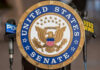Senate Brawl Crowns New Spy Boss United States Senate seal with microphones in front.