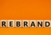 Rebrand Backfires, CEO Out Wooden blocks spelling the word 'REBRAND' on an orange background