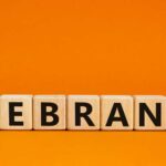 Rebrand Backfires, CEO Out Wooden blocks spelling the word 'REBRAND' on an orange background