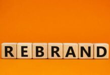 Rebrand Backfires, CEO Out Wooden blocks spelling the word 'REBRAND' on an orange background