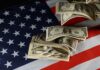 $1B Fine Stuns American Tech Firm Dollar bills arranged on an American flag