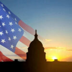 U.S. Capitol silhouette with American flag and sunrise.