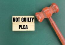 Guilty Plea Bombshell: Convict Cries ‘Coerced’ A wooden gavel next to a sign that reads 'NOT GUILTY PLEA'