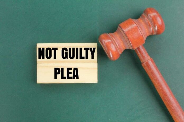 Judge's,Gavel,And,A,White,Paper,With,The,Words,Not A wooden gavel next to a sign that reads 'NOT GUILTY PLEA'