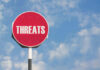 Ohio Jobs Threat Sparks GOP Revolt Red sign with the word threats against sky