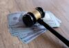 Judge Drops Hammer On $100M Deli Judge’s gavel resting on a stack of US hundred-dollar bills