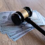 Judge Drops Hammer On $100M Deli Judge’s gavel resting on a stack of US hundred-dollar bills