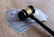 Judge Drops Hammer On $100M Deli Judge’s gavel resting on a stack of US hundred-dollar bills