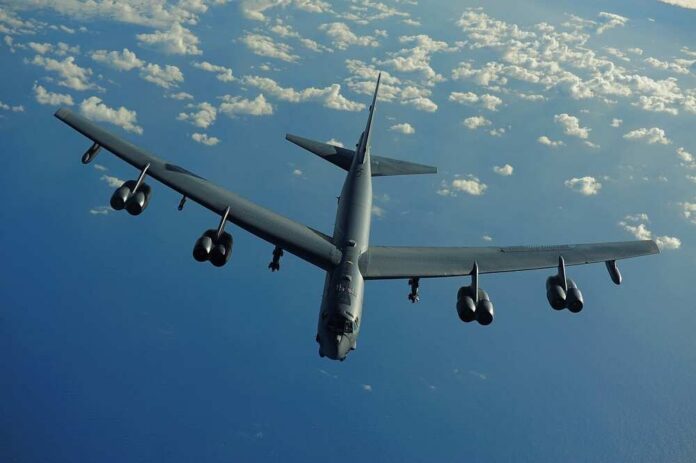 Strategic B-52 bomber aircraft flying over the ocean